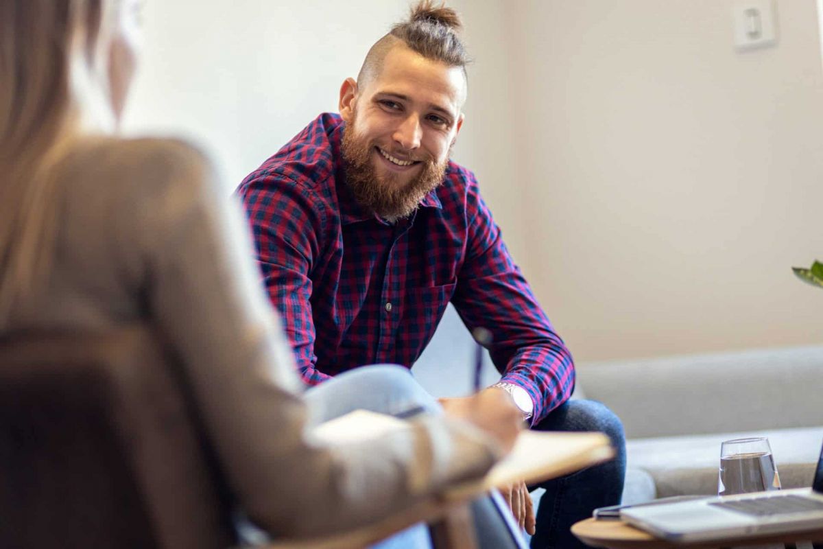 happy man is in a one on one individual counseling session with his therapist