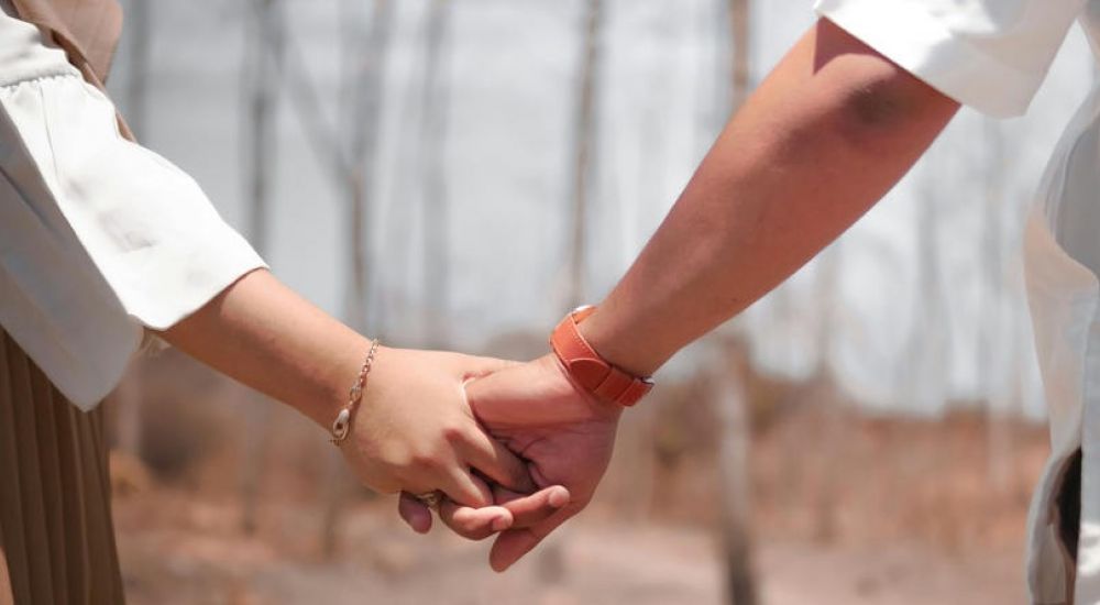 two people holding hands in the forest because they are free from addiction