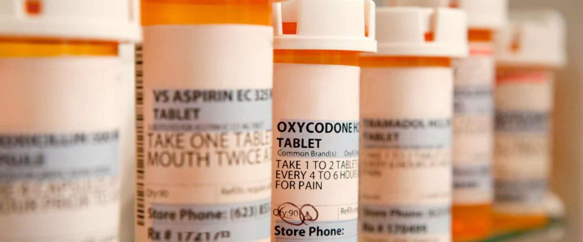 Pill bottles sit on a shelve in a bathroom representing oxycodone addiction