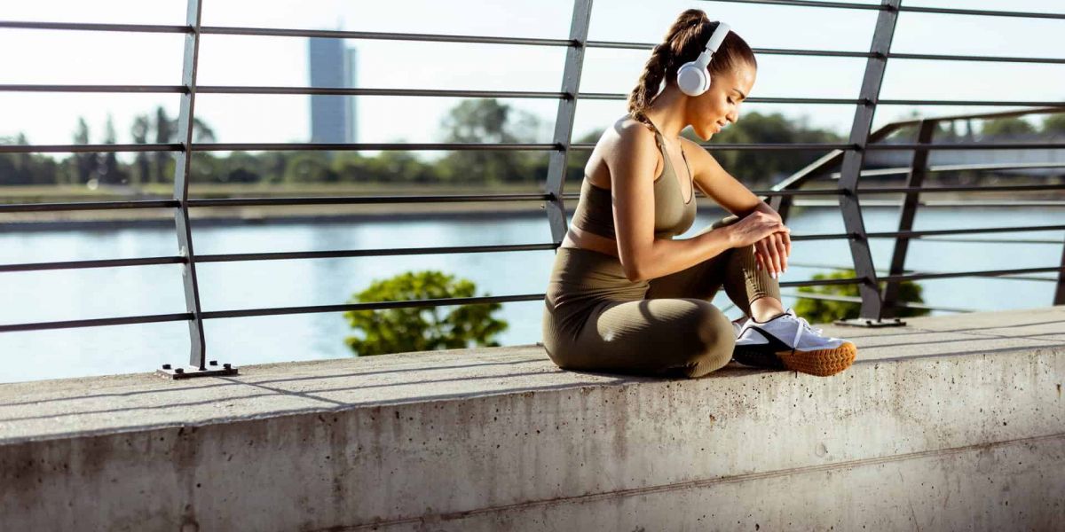 young girl sits on a bridge over looking Nashville as she listens to music recovering from substance abuse