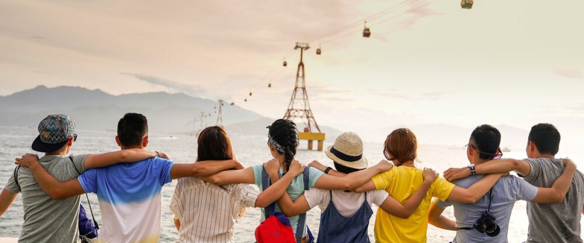 Group of young adults sitting by each other looking at the sky