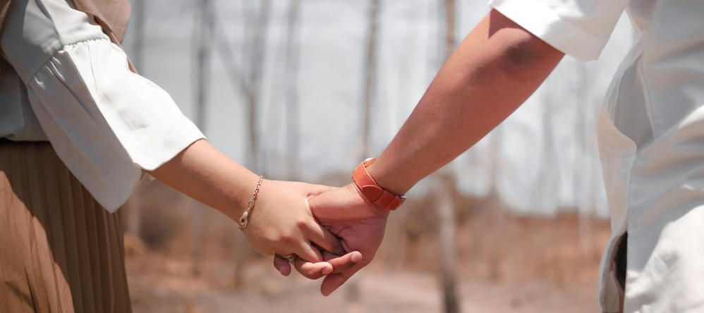 two people holding hands in the forest because they are free from addiction